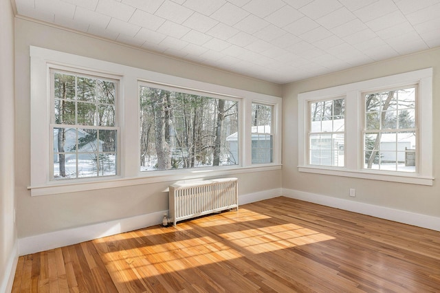 unfurnished sunroom with a healthy amount of sunlight and radiator heating unit