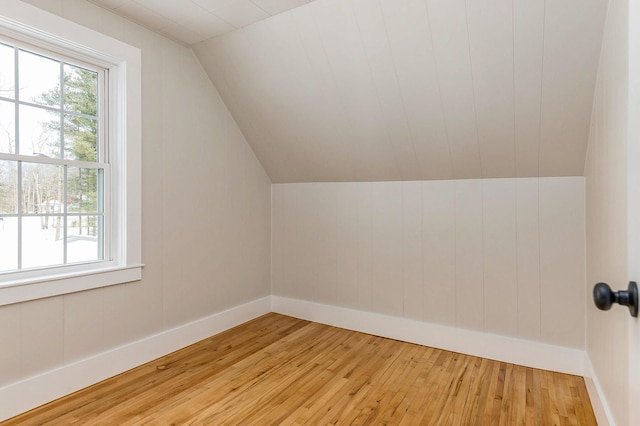 additional living space with vaulted ceiling and light wood-type flooring