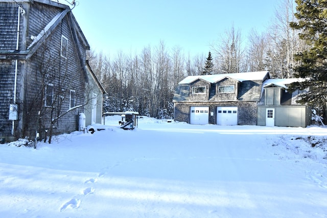 view of snow covered exterior featuring a garage