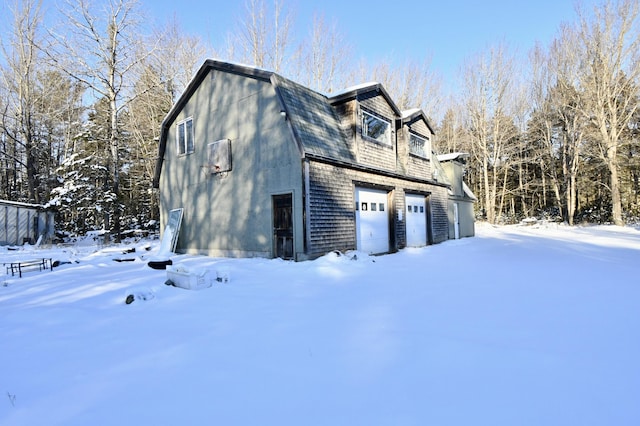 snow covered property featuring a garage