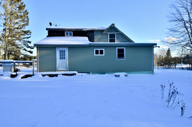 view of snow covered rear of property