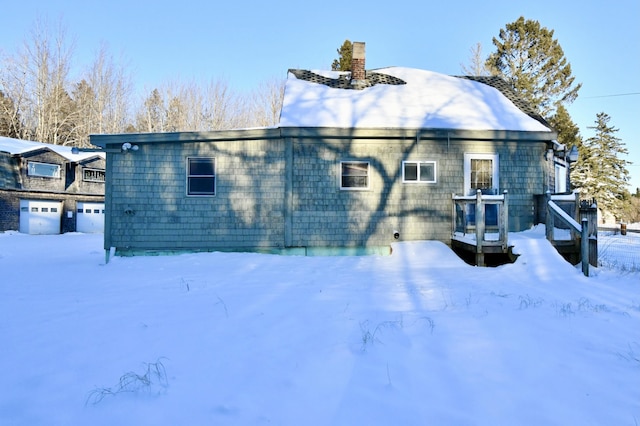 view of snow covered back of property