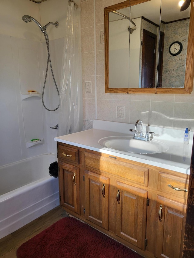 bathroom with shower / tub combo with curtain, backsplash, vanity, and tile walls