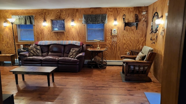 living room with dark wood-type flooring, wooden walls, and baseboard heating