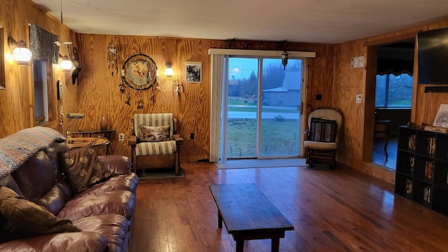 living room featuring dark hardwood / wood-style flooring and wood walls