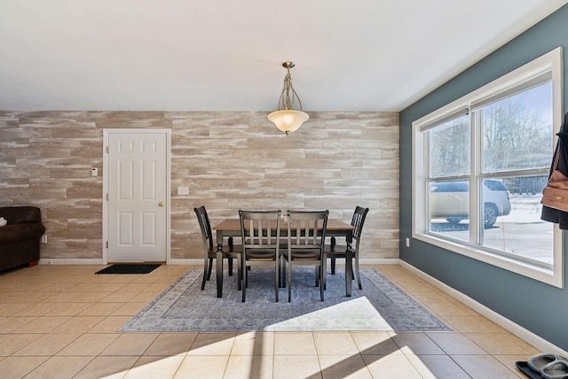 dining area with light tile patterned floors and wooden walls