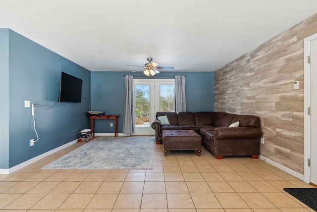 tiled living room with ceiling fan and wood walls