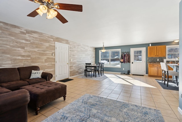 tiled living room featuring ceiling fan and sink