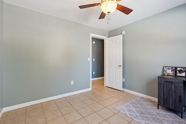 empty room featuring light tile patterned floors and ceiling fan