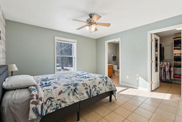 tiled bedroom featuring ceiling fan, connected bathroom, a spacious closet, and a closet