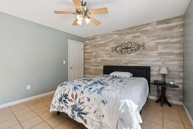 bedroom featuring tile patterned floors, ceiling fan, and wood walls