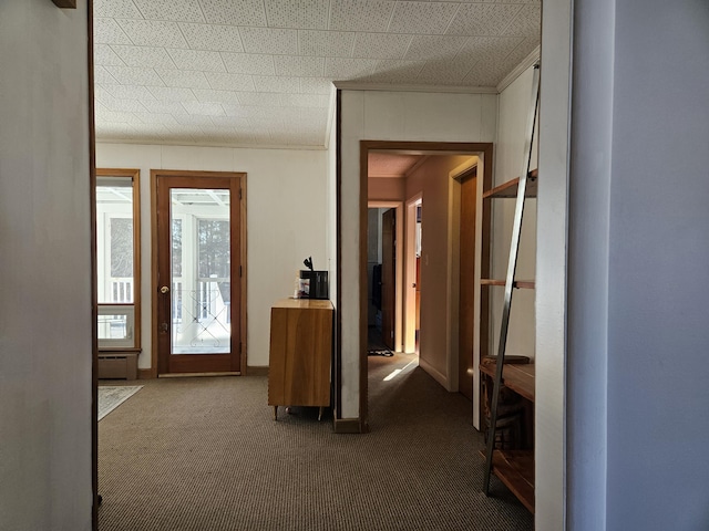 hallway with dark carpet and ornamental molding