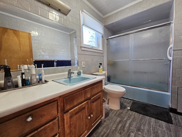 full bathroom with toilet, enclosed tub / shower combo, hardwood / wood-style floors, ornamental molding, and vanity