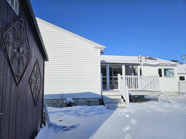 view of snow covered exterior with a deck