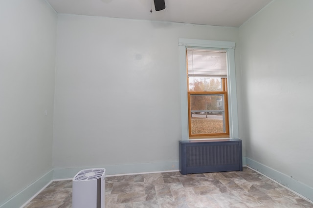 empty room with radiator heating unit and ceiling fan