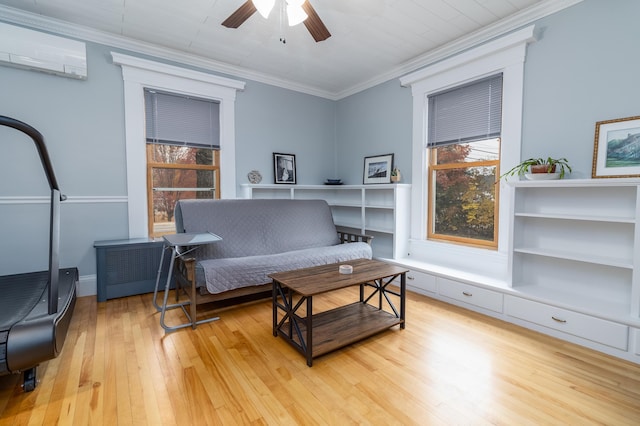 living area with crown molding, ceiling fan, a wall mounted AC, and light hardwood / wood-style floors