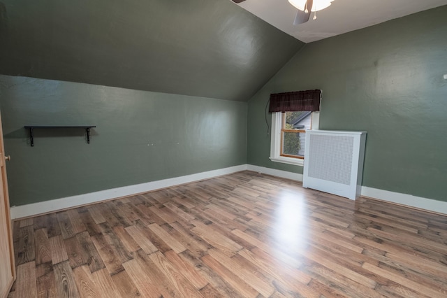 additional living space with hardwood / wood-style flooring, lofted ceiling, and ceiling fan