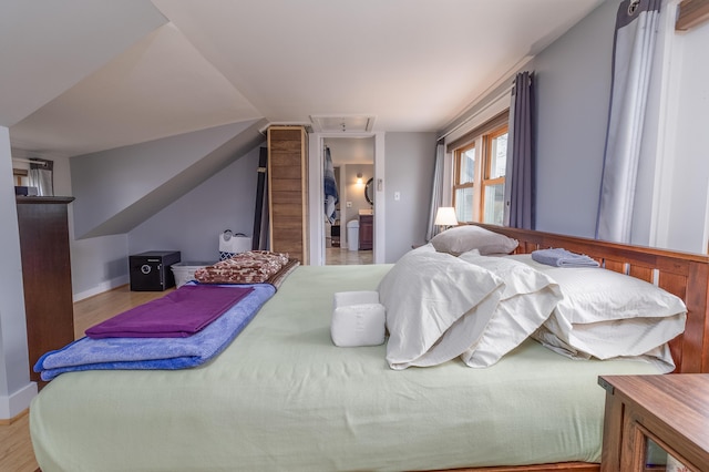 bedroom with lofted ceiling and light wood-type flooring