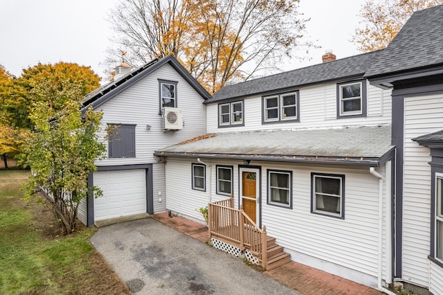 front facade with a garage and ac unit