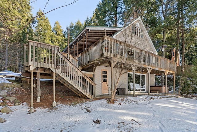 snow covered house with a wooden deck