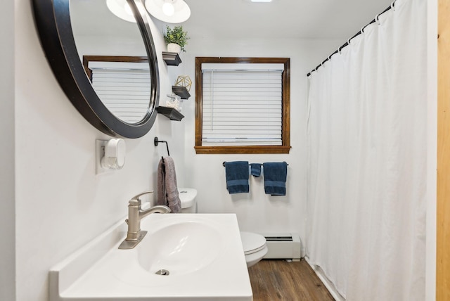 bathroom featuring wood-type flooring, a baseboard heating unit, sink, and toilet