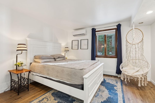 bedroom with hardwood / wood-style floors and a wall mounted AC