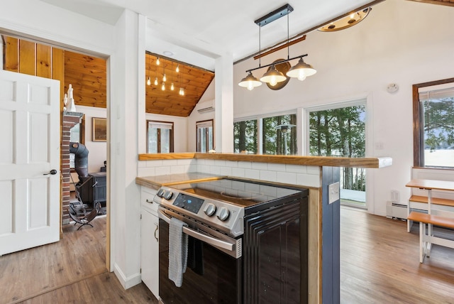 kitchen featuring stainless steel electric range oven, vaulted ceiling, hardwood / wood-style floors, pendant lighting, and kitchen peninsula