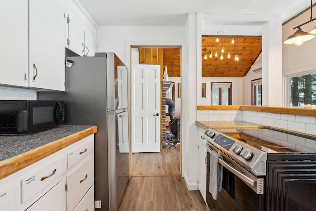 kitchen featuring tasteful backsplash, stainless steel appliances, light hardwood / wood-style floors, and white cabinets