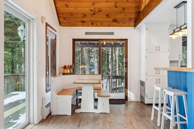 interior space with lofted ceiling, wood ceiling, light hardwood / wood-style flooring, a baseboard heating unit, and breakfast area