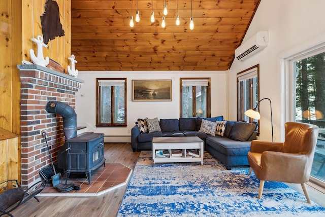 living room featuring vaulted ceiling, hardwood / wood-style floors, a wood stove, baseboard heating, and a wall unit AC