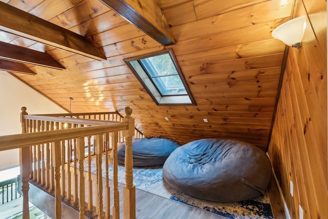 additional living space with hardwood / wood-style flooring, vaulted ceiling with skylight, wood ceiling, and wood walls