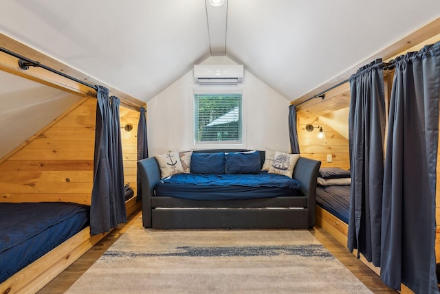 bedroom with hardwood / wood-style flooring, lofted ceiling, a wall unit AC, and wood walls