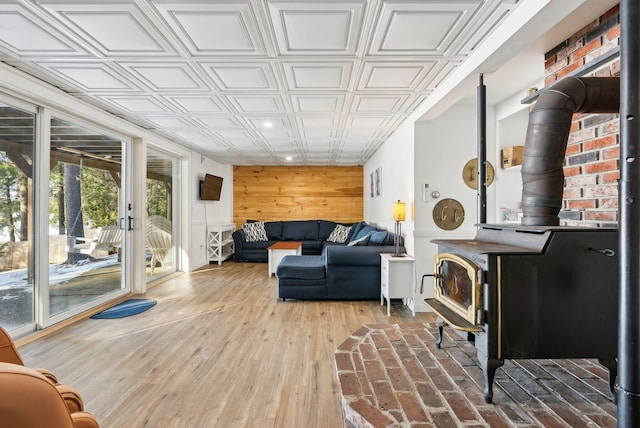 living room featuring wooden walls, hardwood / wood-style floors, and a wood stove