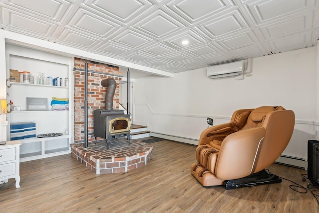 sitting room featuring baseboard heating, a wall mounted AC, light wood-type flooring, and a wood stove