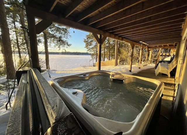 exterior space with a water view and a hot tub