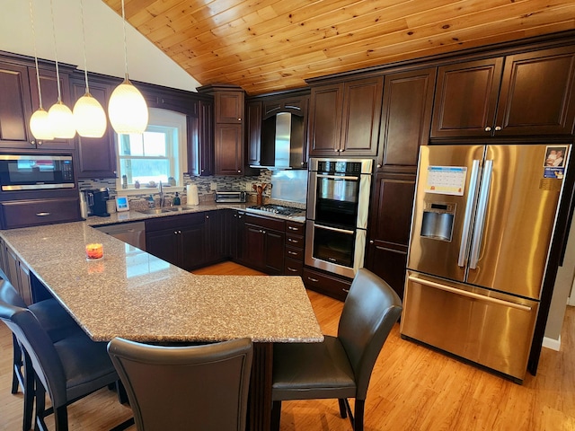 305 Fuller Rd, Easton, ME 04740 - kitchen featuring dark brown cabinetry, a sink, a kitchen breakfast bar, vaulted ceiling, and stainless steel appliances