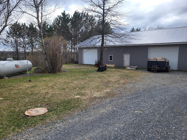 305 Fuller Rd, Easton, ME 04740 - view of side of home featuring driveway, a garage, an outdoor structure, and metal roof