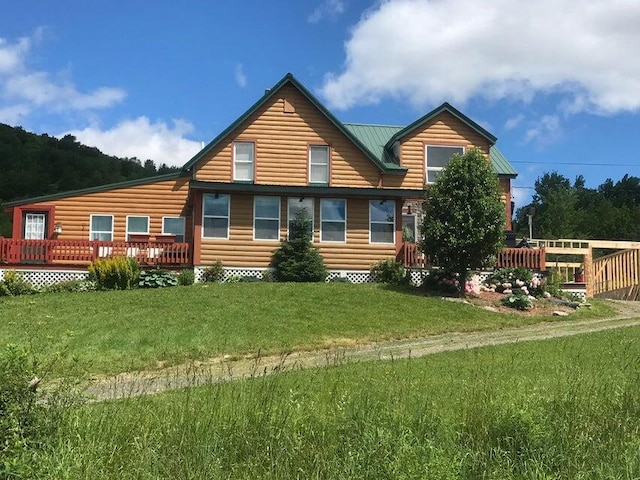 back of property featuring a deck and a yard