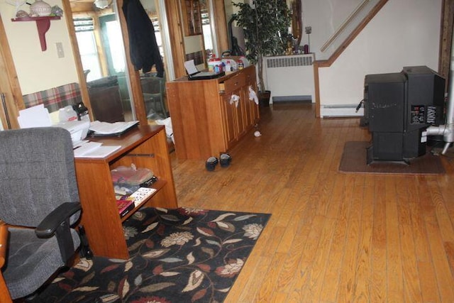 interior space with hardwood / wood-style flooring, radiator, and a baseboard heating unit