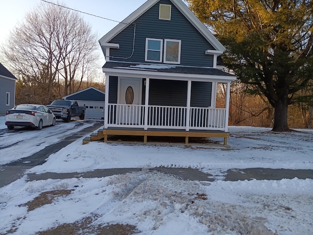 view of front of property with a garage, an outdoor structure, and a porch