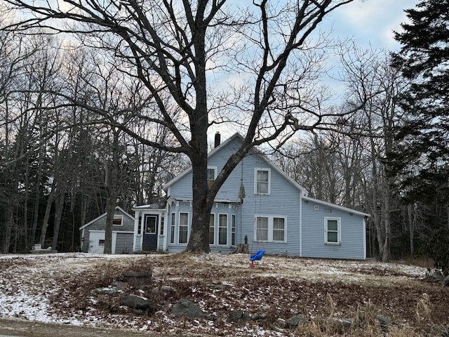 view of front of home featuring a chimney and a detached garage