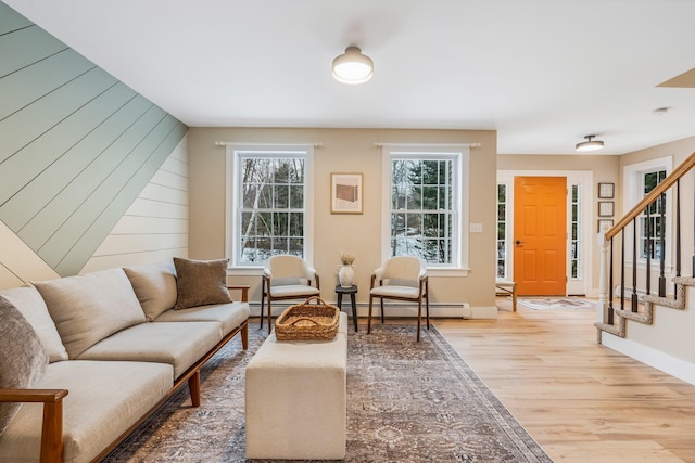 sitting room featuring wood walls, hardwood / wood-style floors, and a baseboard radiator