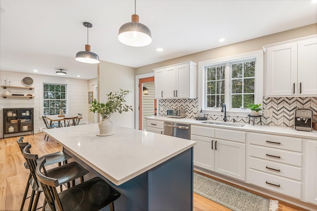 kitchen with white cabinetry, sink, and pendant lighting