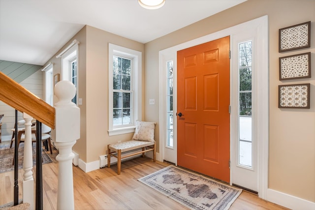 entrance foyer featuring a healthy amount of sunlight, light hardwood / wood-style flooring, and baseboard heating