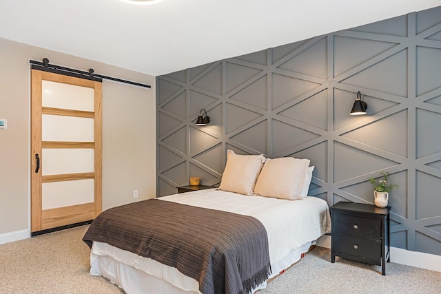 bedroom with light colored carpet and a barn door