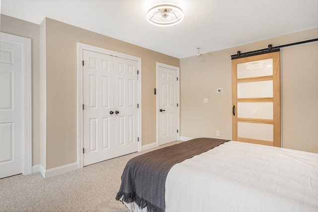 carpeted bedroom featuring a barn door