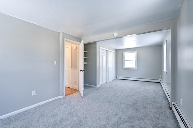 carpeted spare room featuring baseboard heating