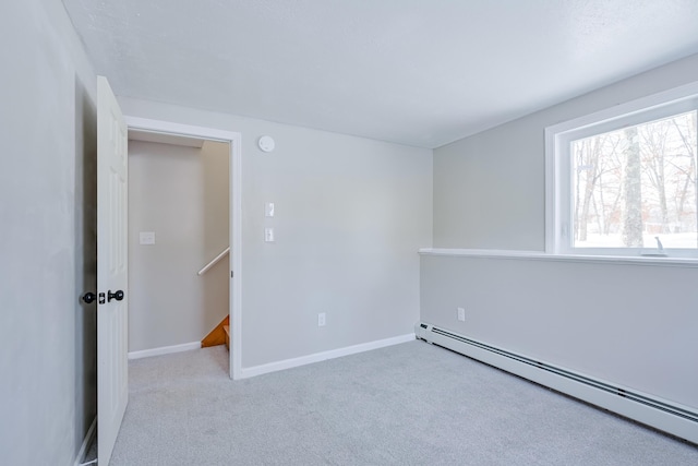 carpeted spare room featuring a baseboard radiator