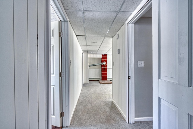 corridor with carpet floors and a drop ceiling