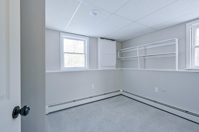 spare room featuring a baseboard radiator and a drop ceiling